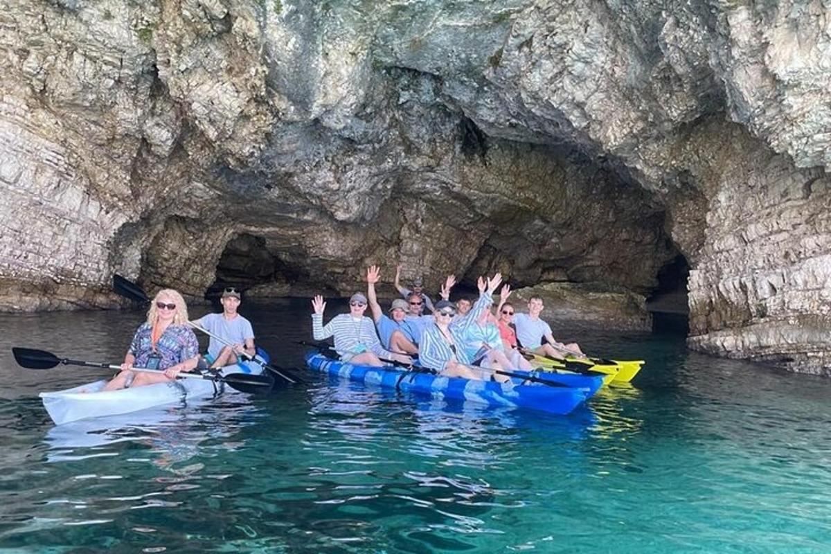 un grup de persones en caiacs davant d'una cova
