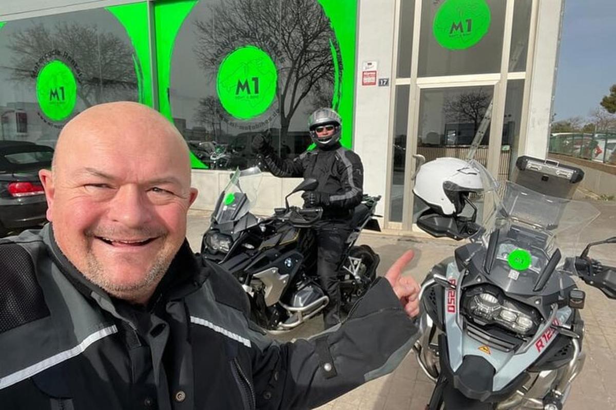 muž ukazuje palec nahoru před motorkou