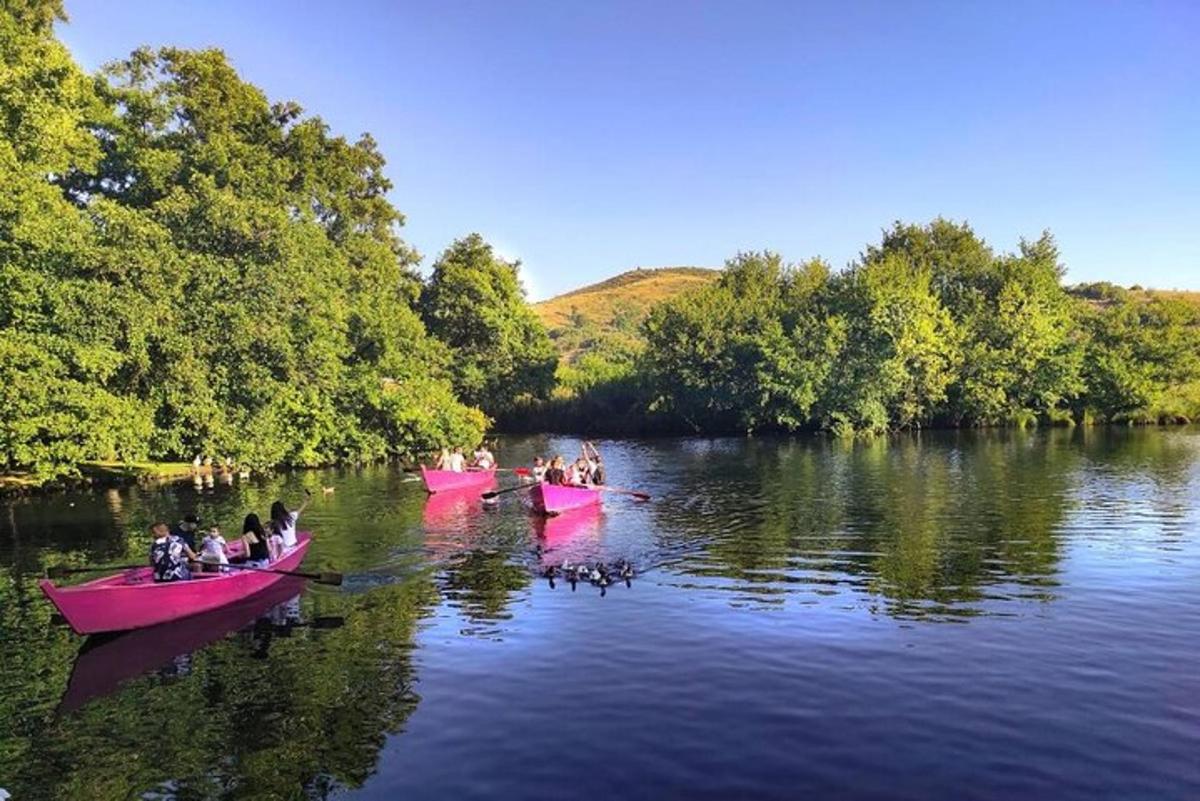 a group of people in pink boats on a river