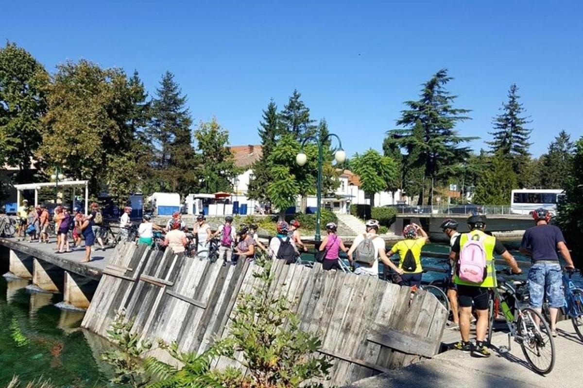 a group of people riding bikes over a wooden bridge
