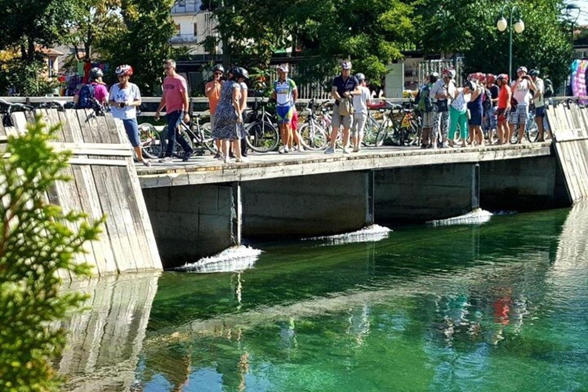 a group of people standing on a bridge over a river