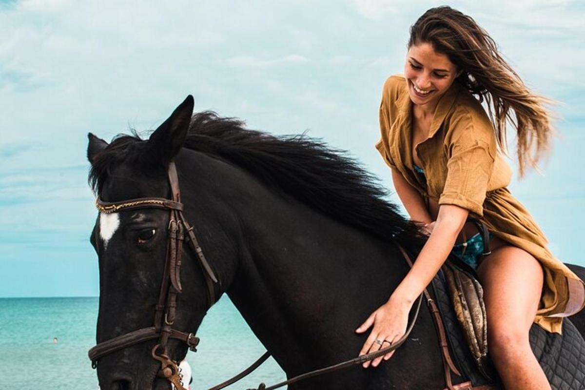 a woman riding a horse on the beach