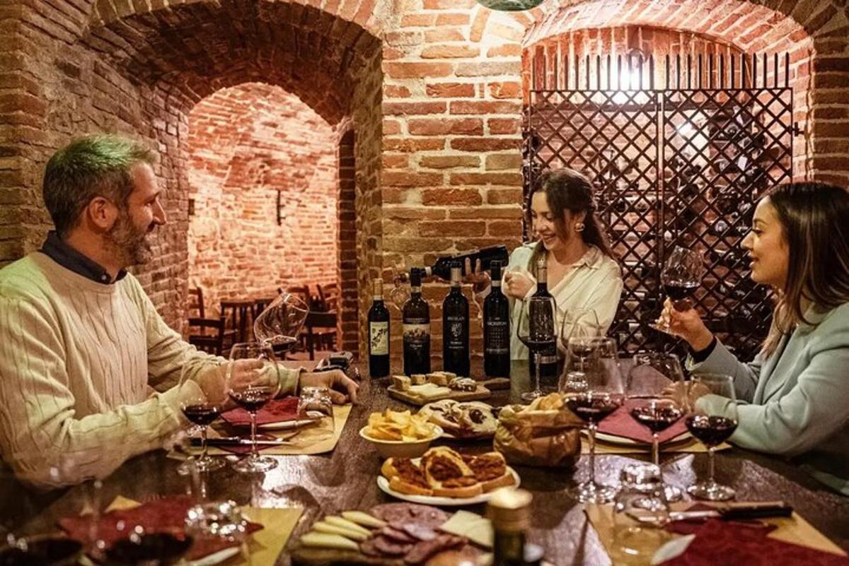un grup de persones assegudes al voltant d'una taula amb copes de vi