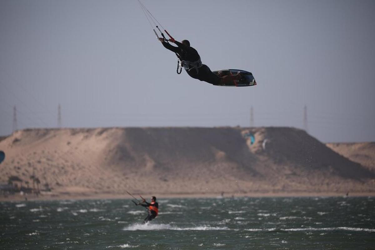 muž letící vzduchem při kitesurfingu v oceánu