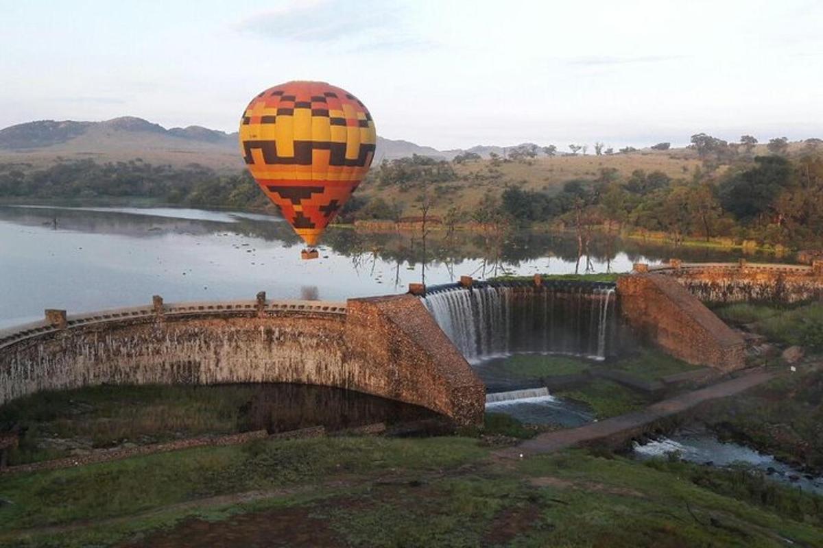 una mongolfiera che vola sopra una cascata