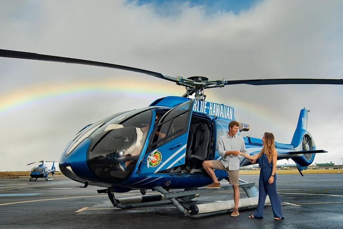vīrietis un sieviete stāv blakus helikopteram