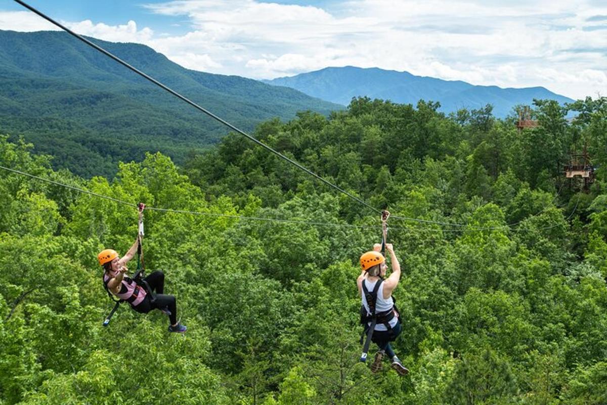 dva lidé na zip line v horách