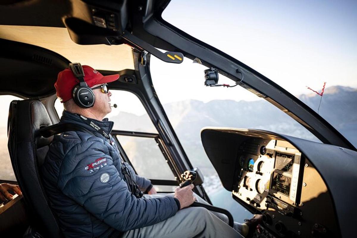 un home assegut en un helicòpter amb auriculars