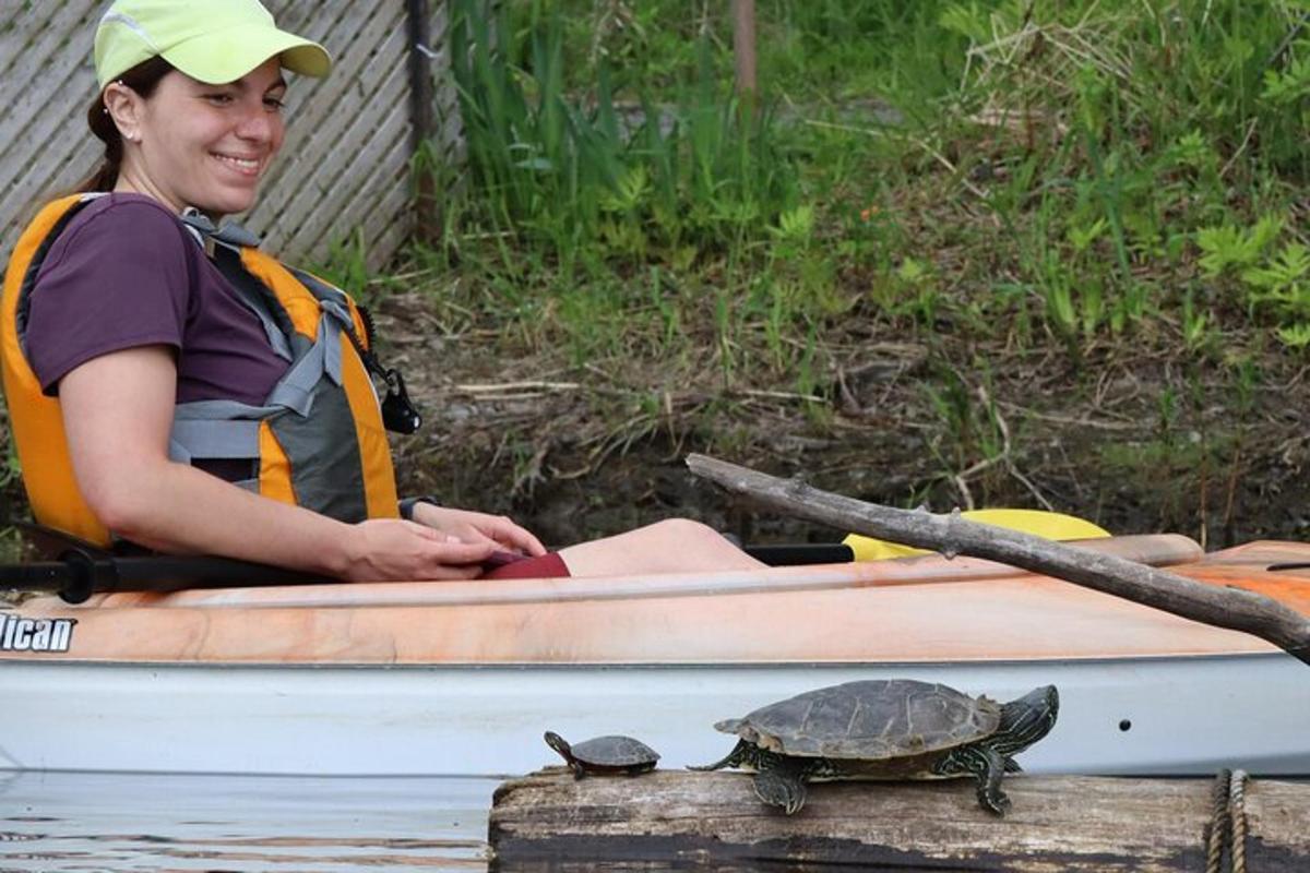 Una mujer sentada en un bote con una tortuga en él.