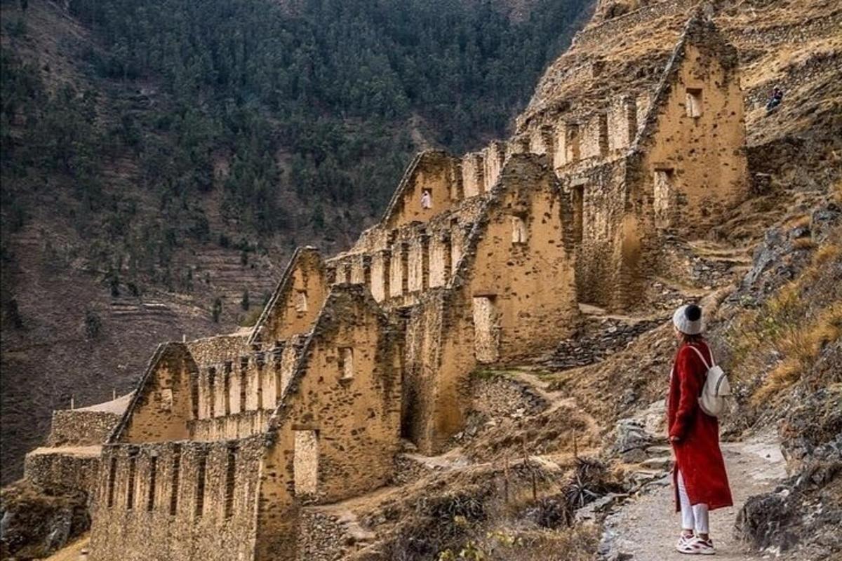una persona in piedi su una montagna che guarda dall'alto un edificio