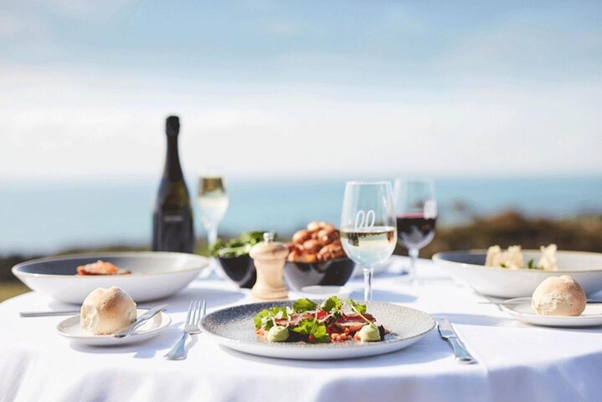 a table with plates of food and glasses of wine