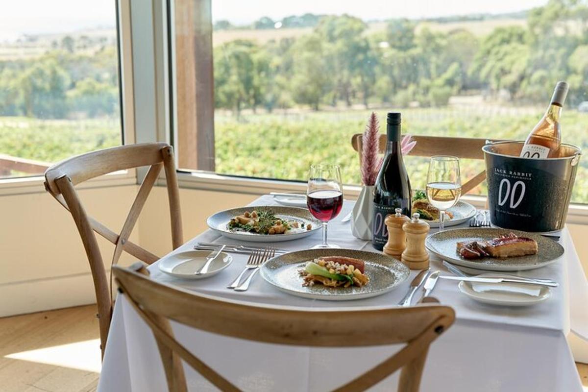 a table with plates of food and glasses of wine