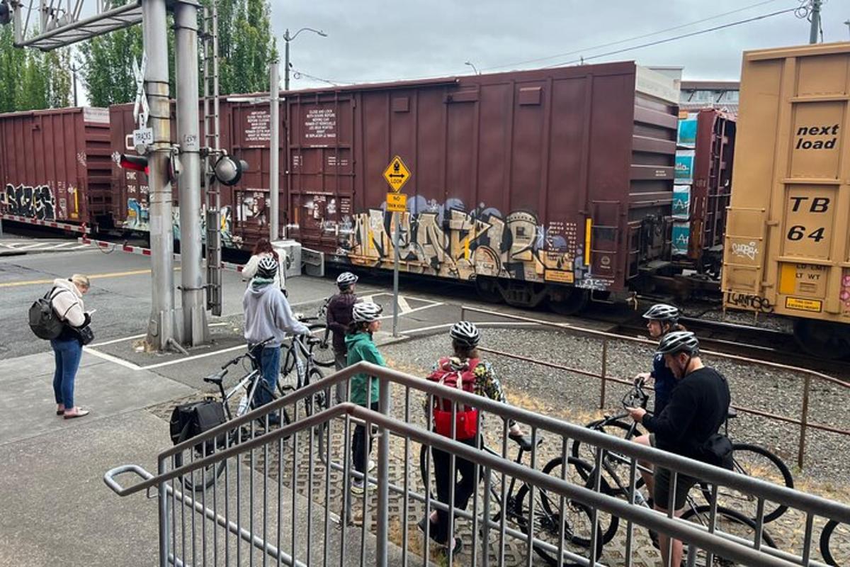 Un grupo de personas de pie junto a un patio de trenes.