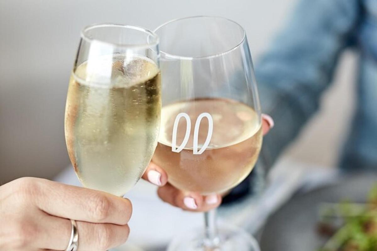 a person holding two glasses of white wine
