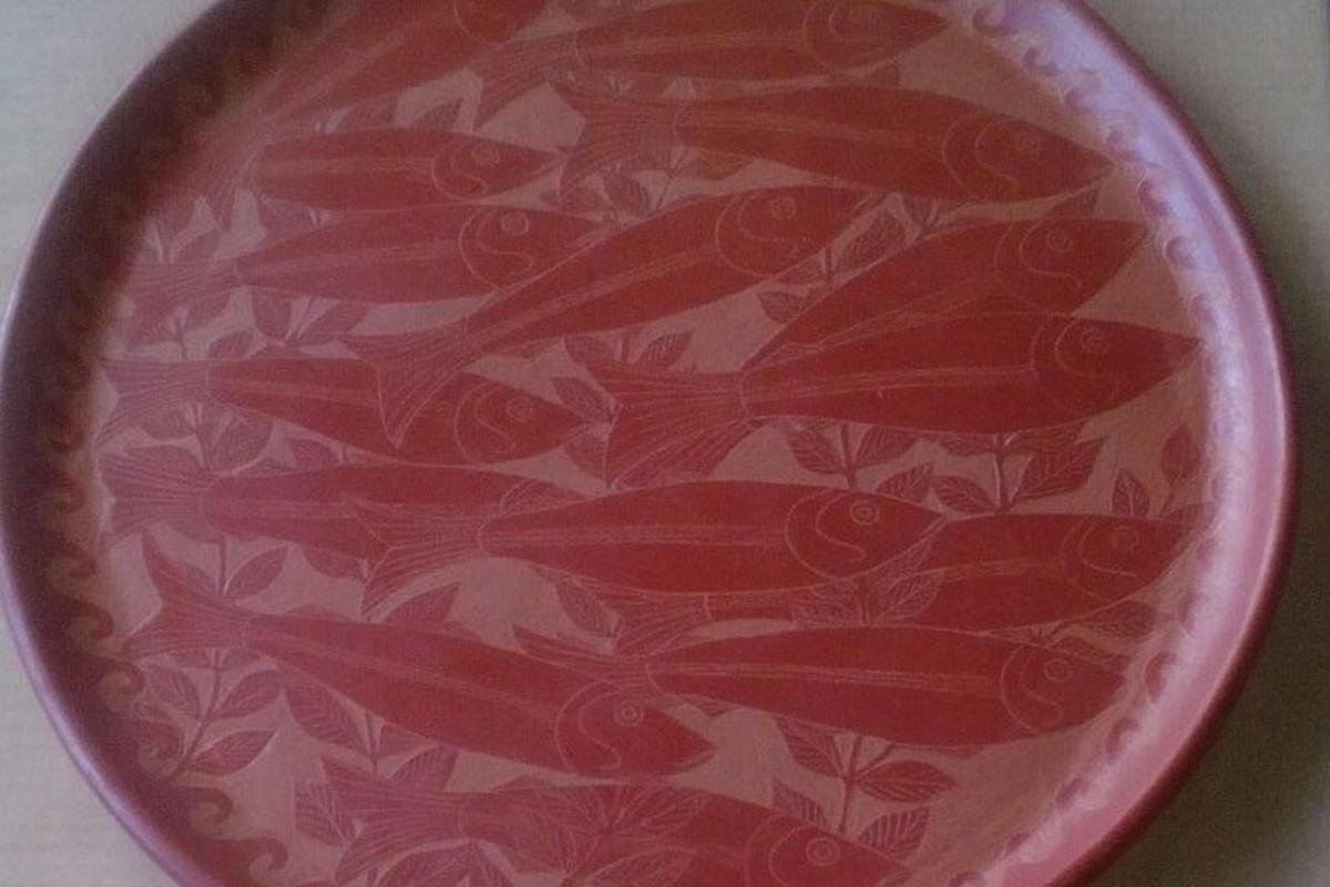 a red plate with red birds painted on it