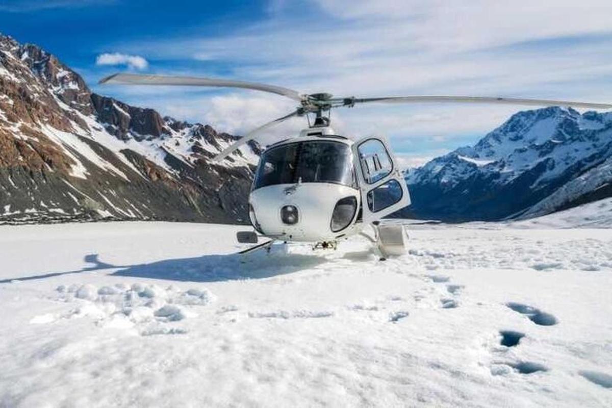 um helicóptero estacionado na neve nas montanhas