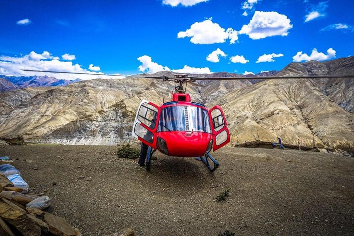 um helicóptero vermelho pousado no topo de uma montanha