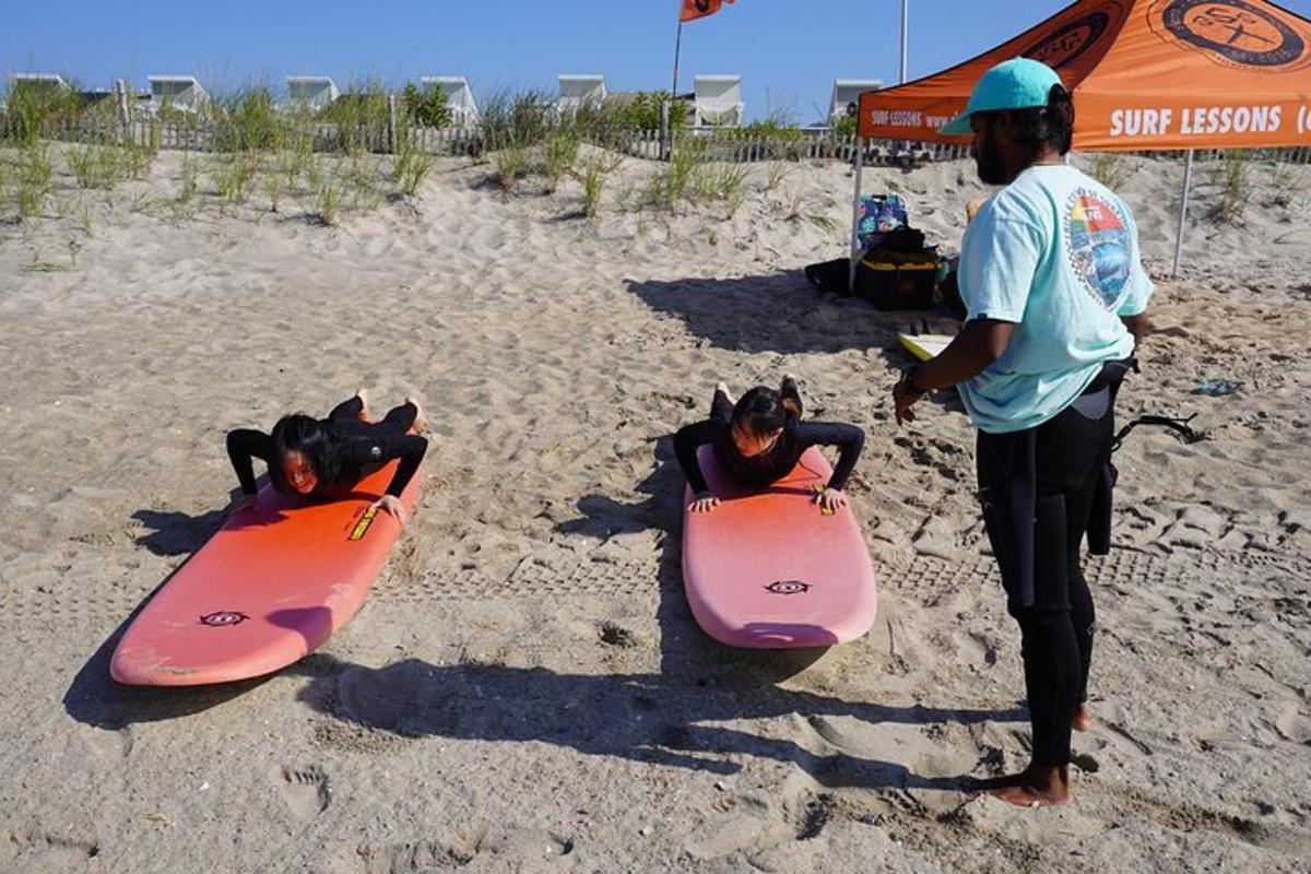 two people are standing on the beach with their surfboards