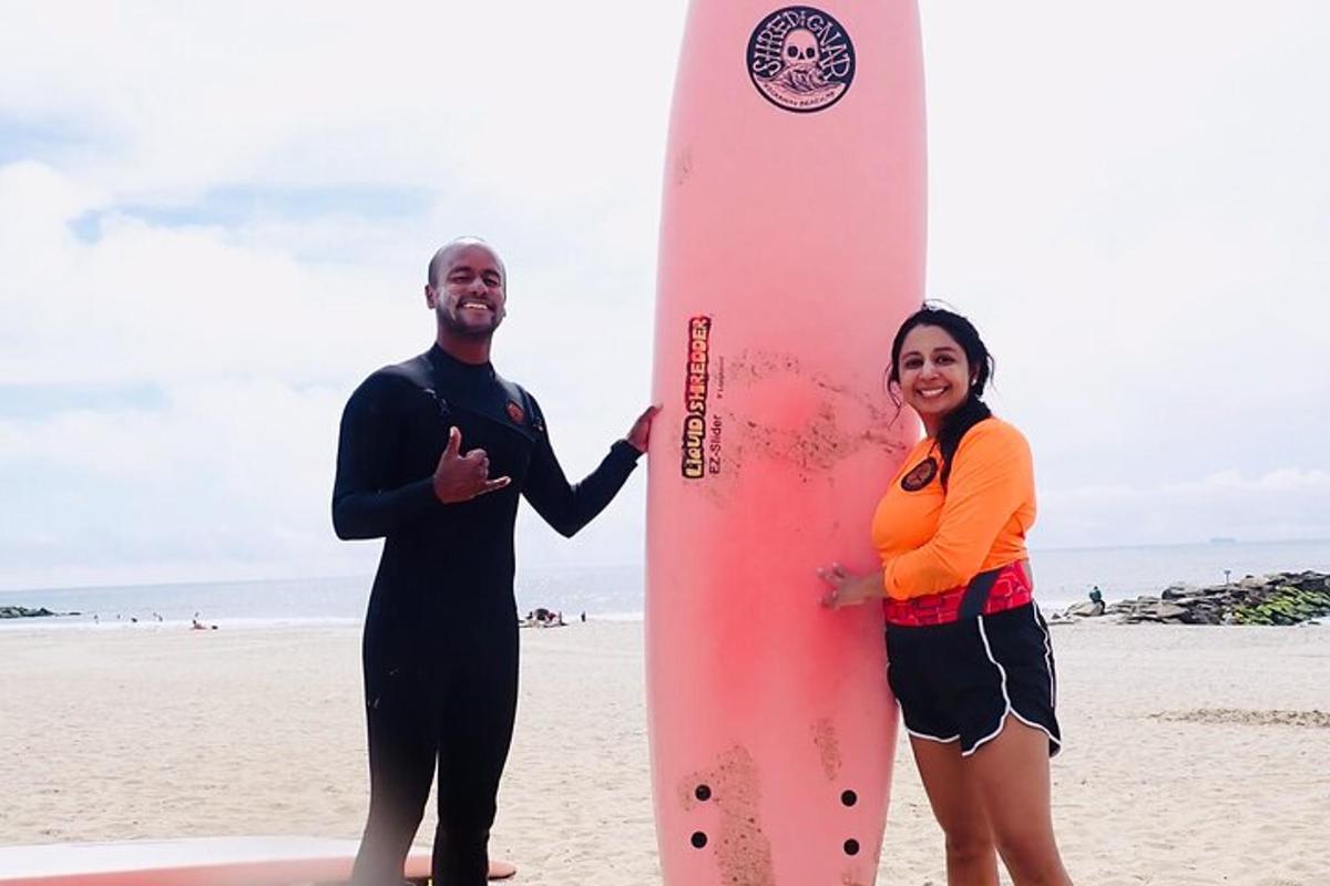 a man and a woman standing next to a surfboard
