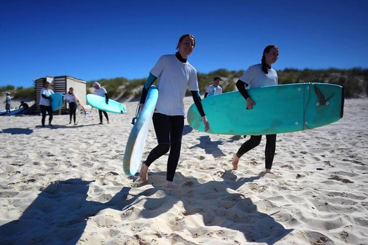due uomini che camminano sulla spiaggia con le loro tavole da surf
