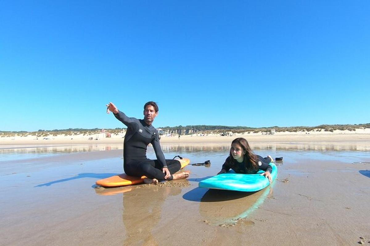 un uomo e una ragazza seduti su tavole da surf sulla spiaggia