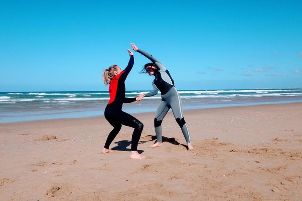 due donne in muta che ballano sulla spiaggia