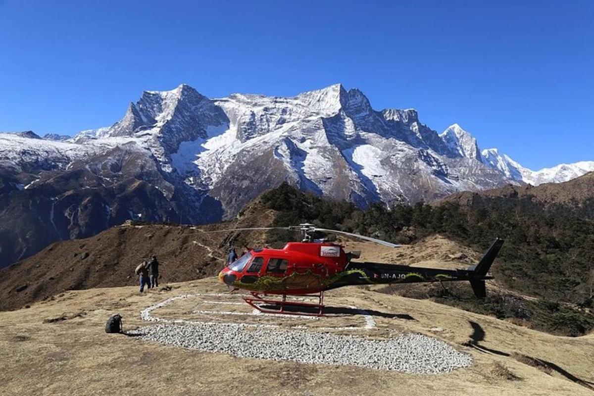 um helicóptero vermelho estacionado no topo de uma montanha