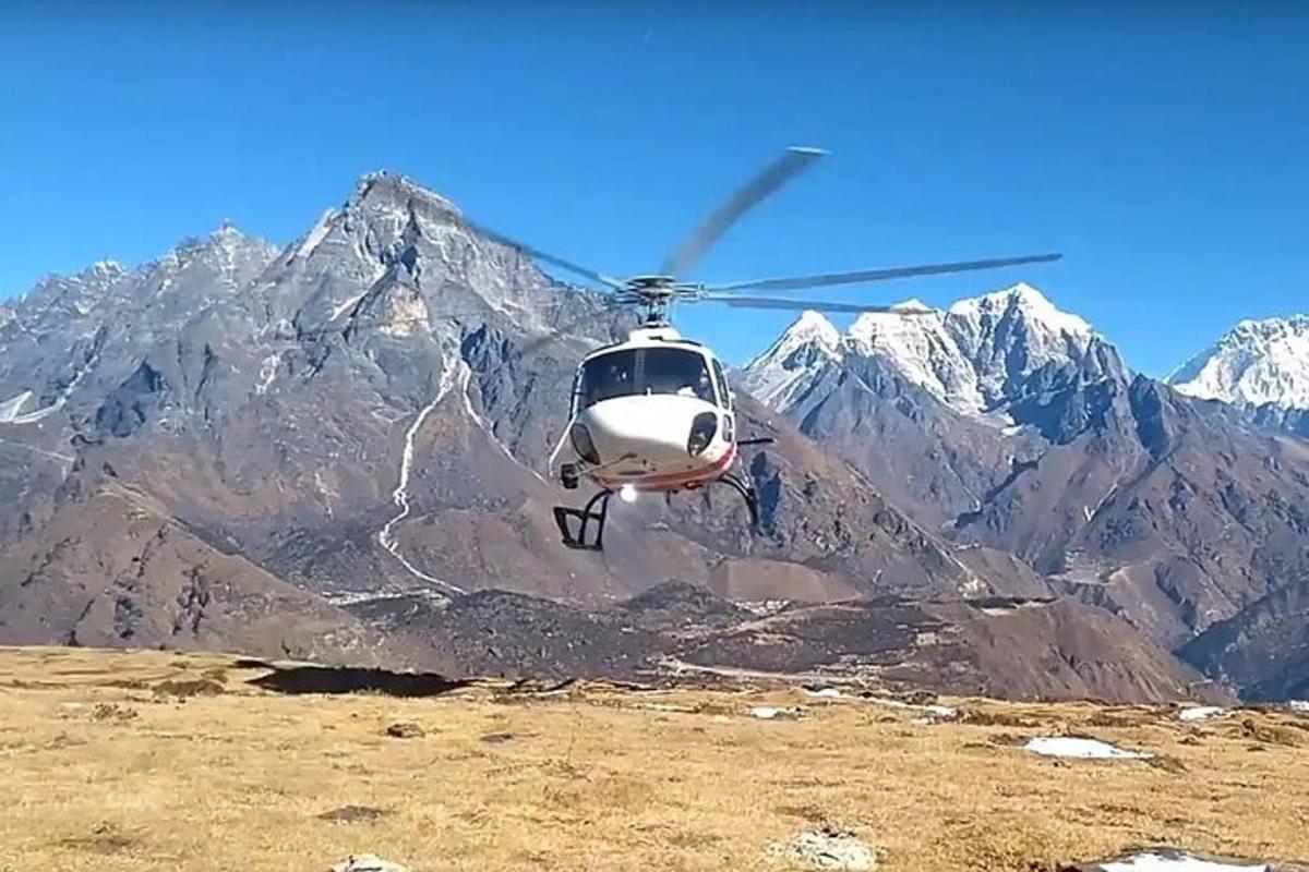 bir dağın önünde uçan bir helikopter