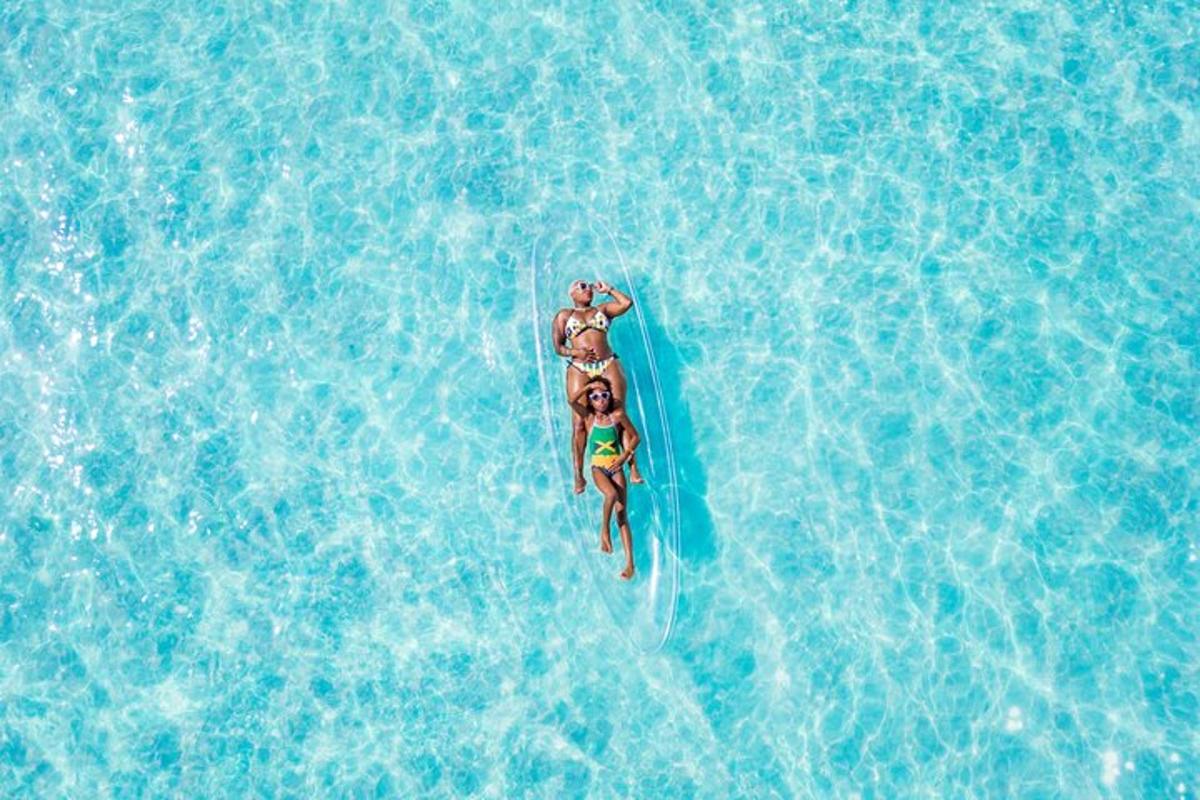 duas pessoas andando de prancha de surfe em uma piscina de água