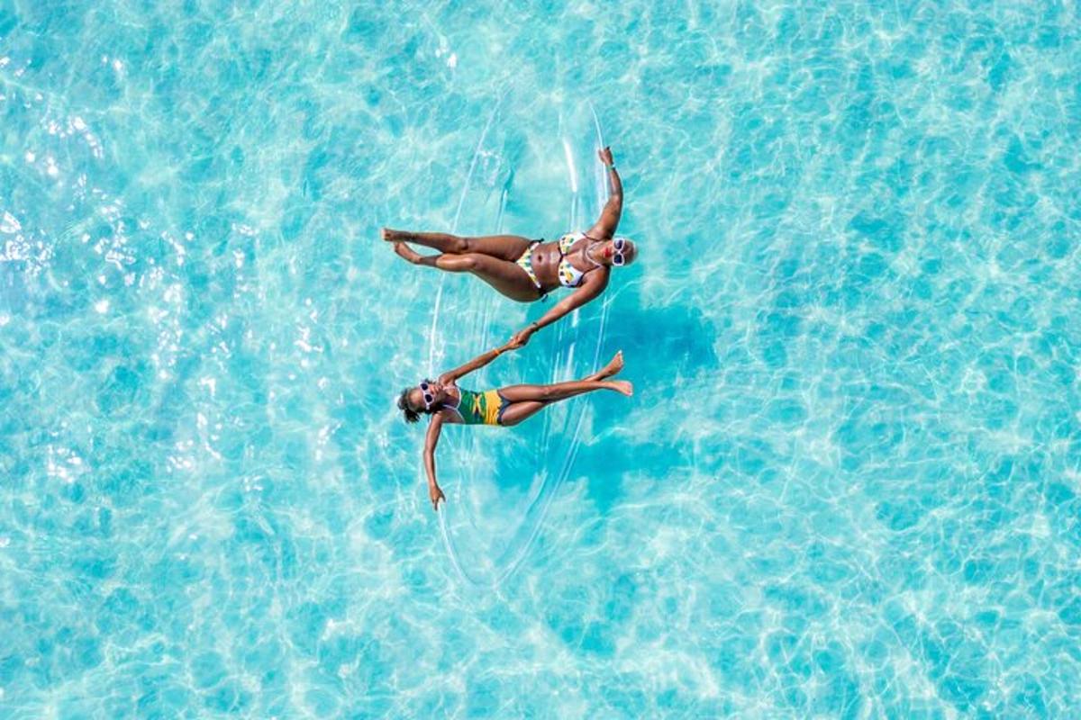 duas pessoas estão brincando na água azul