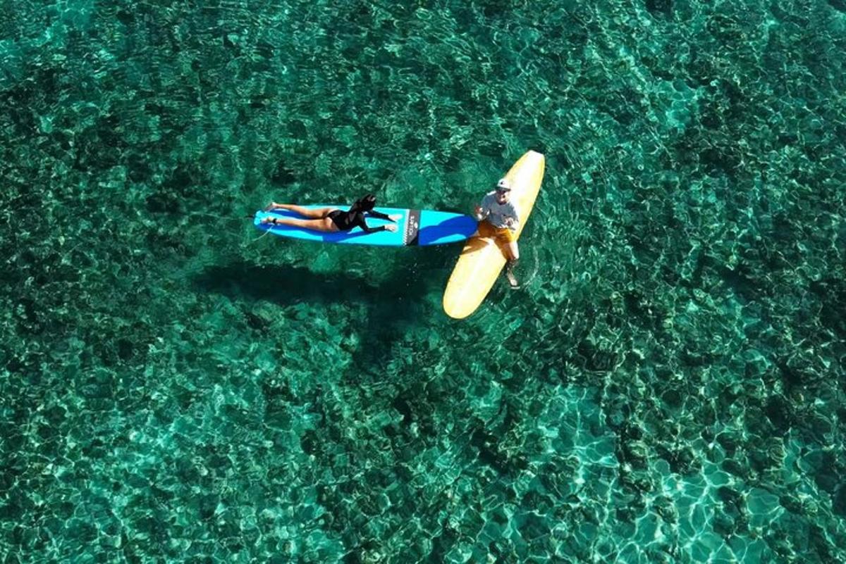 eine Person, die auf einem Surfbrett im Wasser liegt
