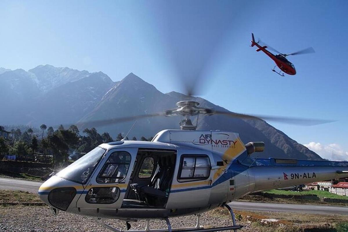 Un helicóptero estacionado en una pista con montañas al fondo.