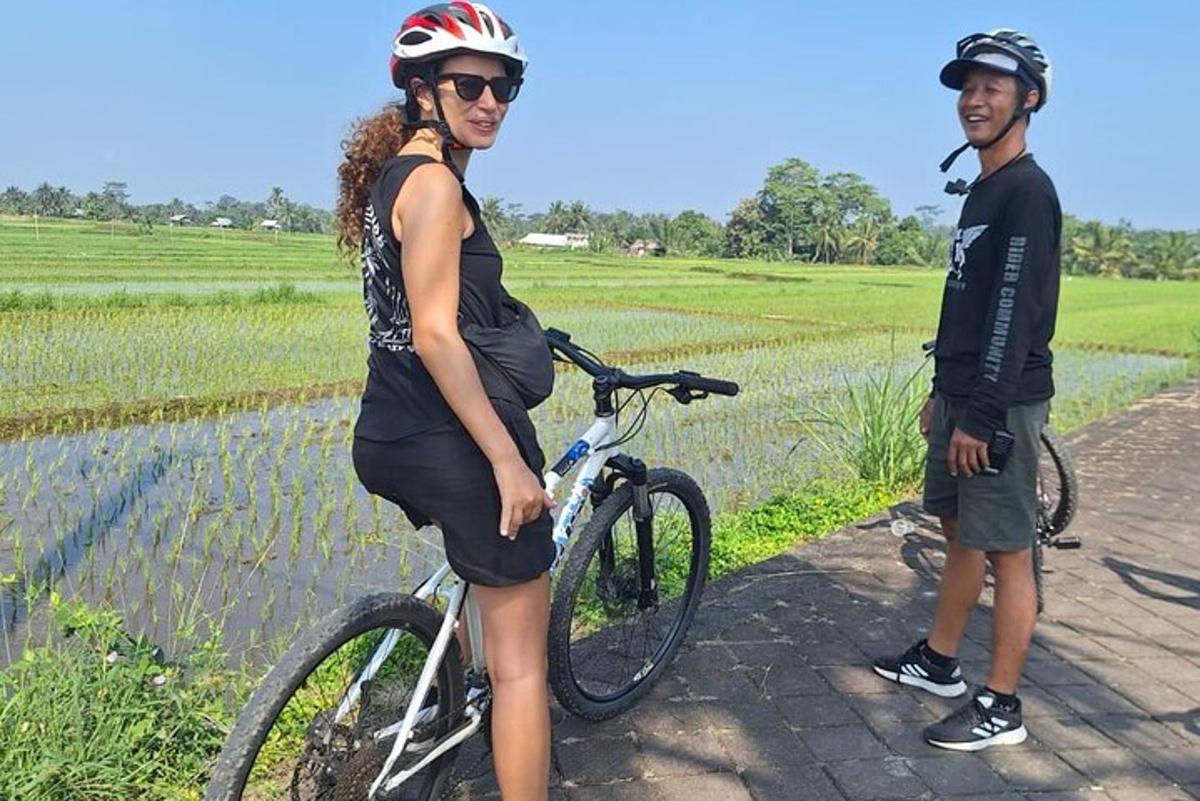 Un hombre y una mujer de pie junto a una bicicleta