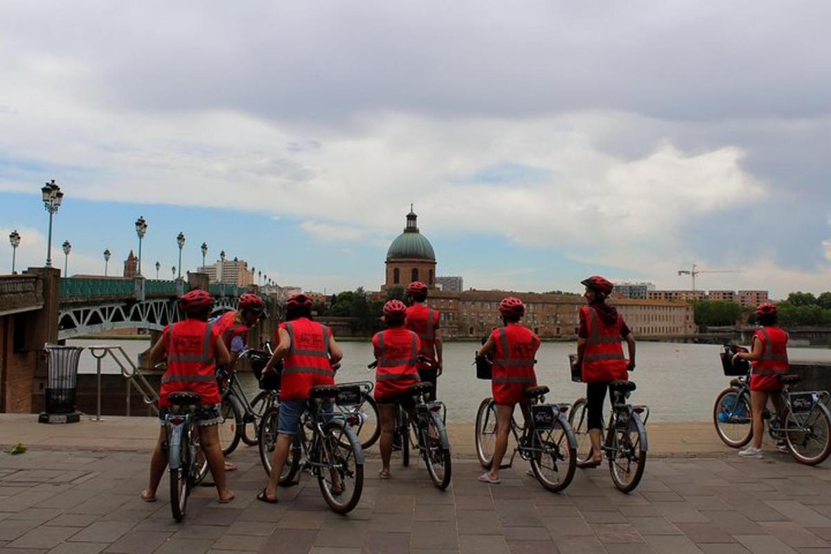 un grup de oameni în cămăși roșii pe biciclete