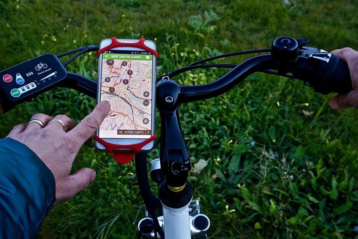 osoba držící mobilní telefon na kole