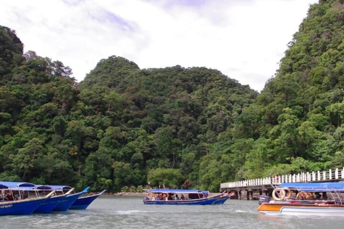 three boats in the water next to a mountain