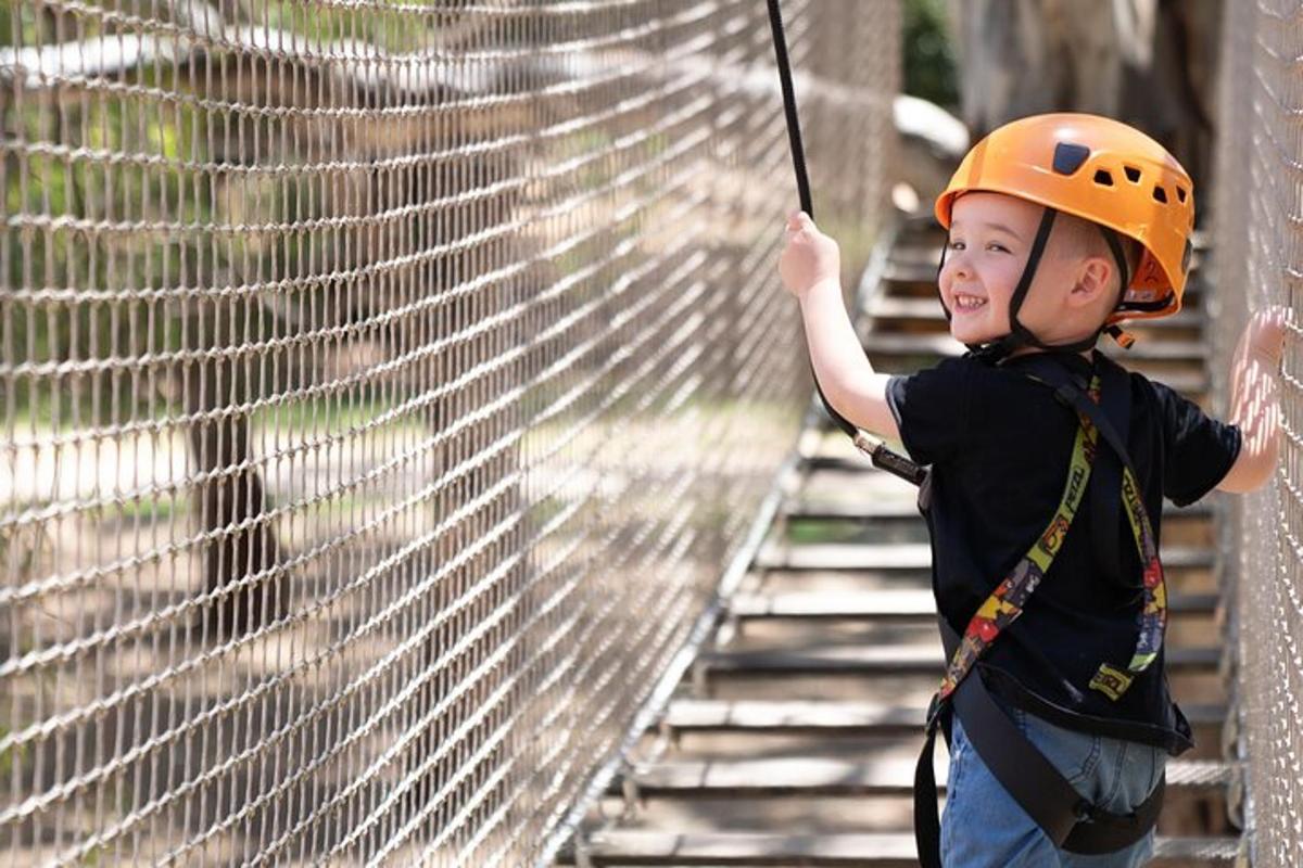 mladý chlapec v oranžové helmě na zip line