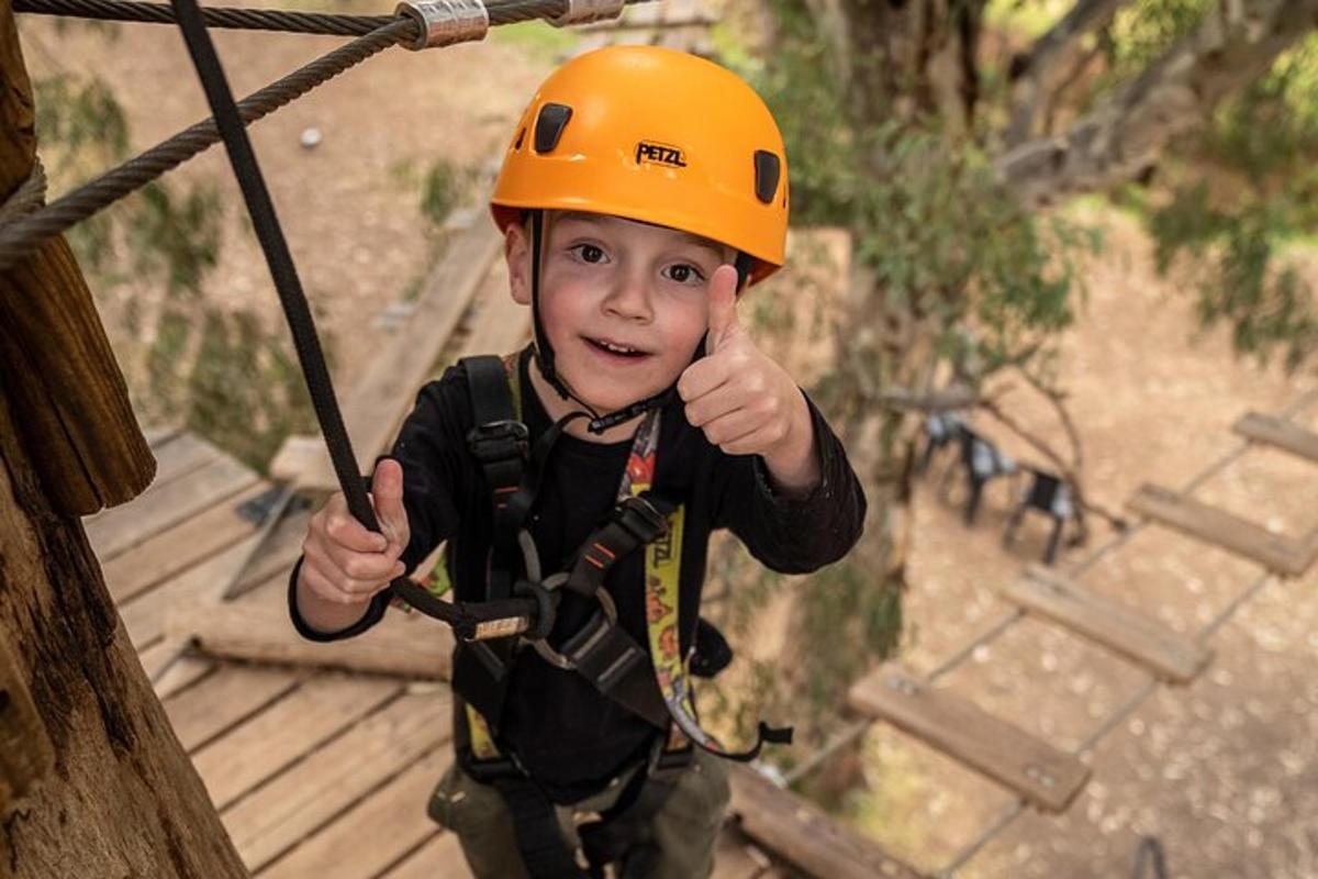 mladý chlapec v oranžové helmě na zip line