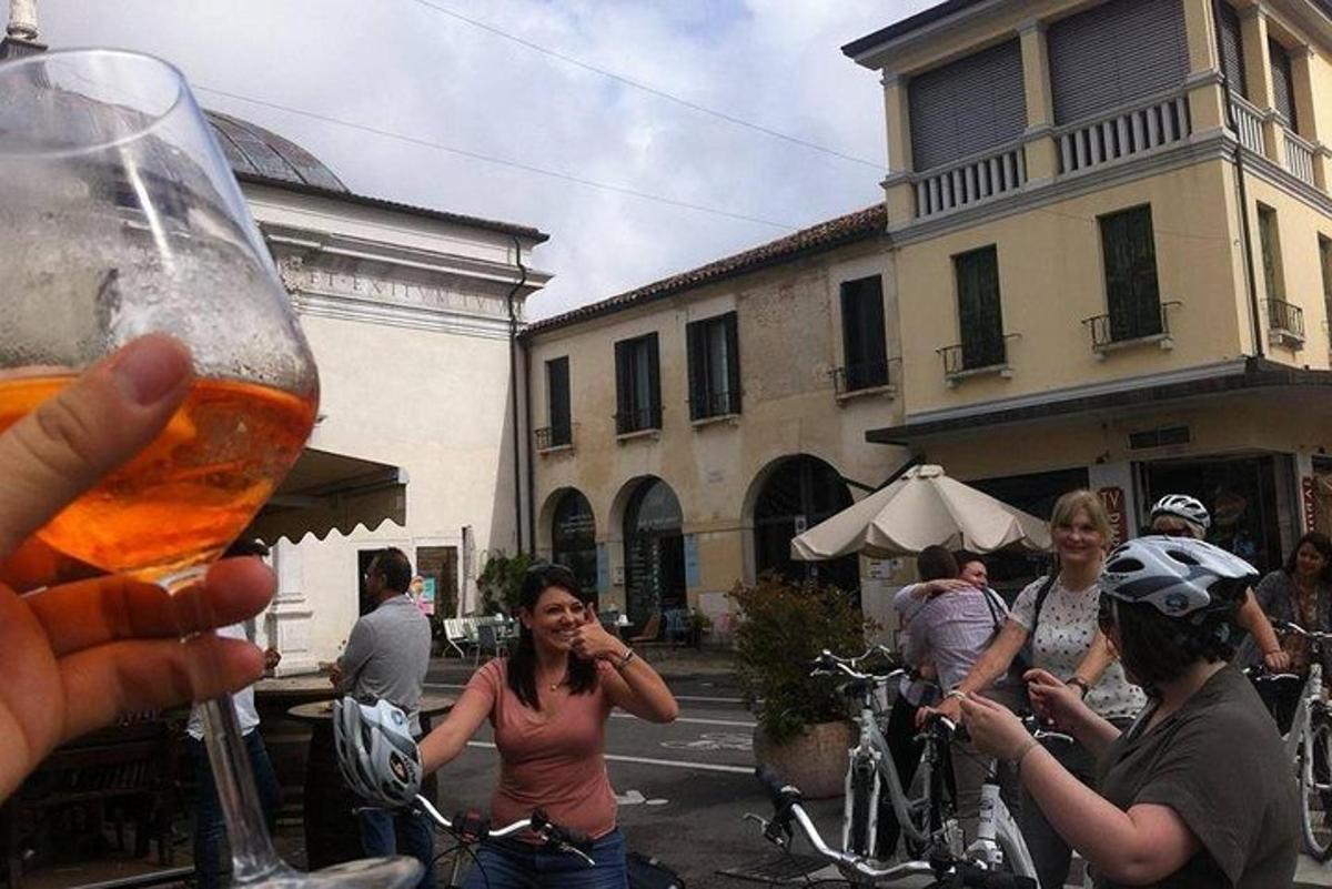 una persona sosteniendo un vaso de cerveza frente a un grupo de personas