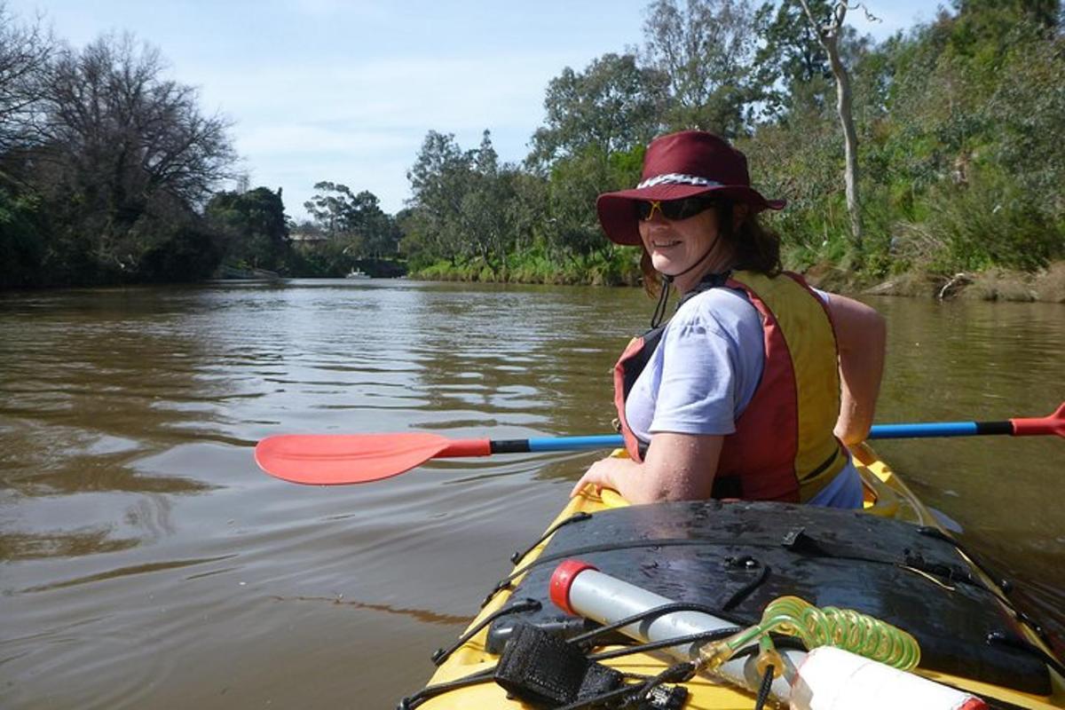 một người phụ nữ chèo thuyền kayak trên sông