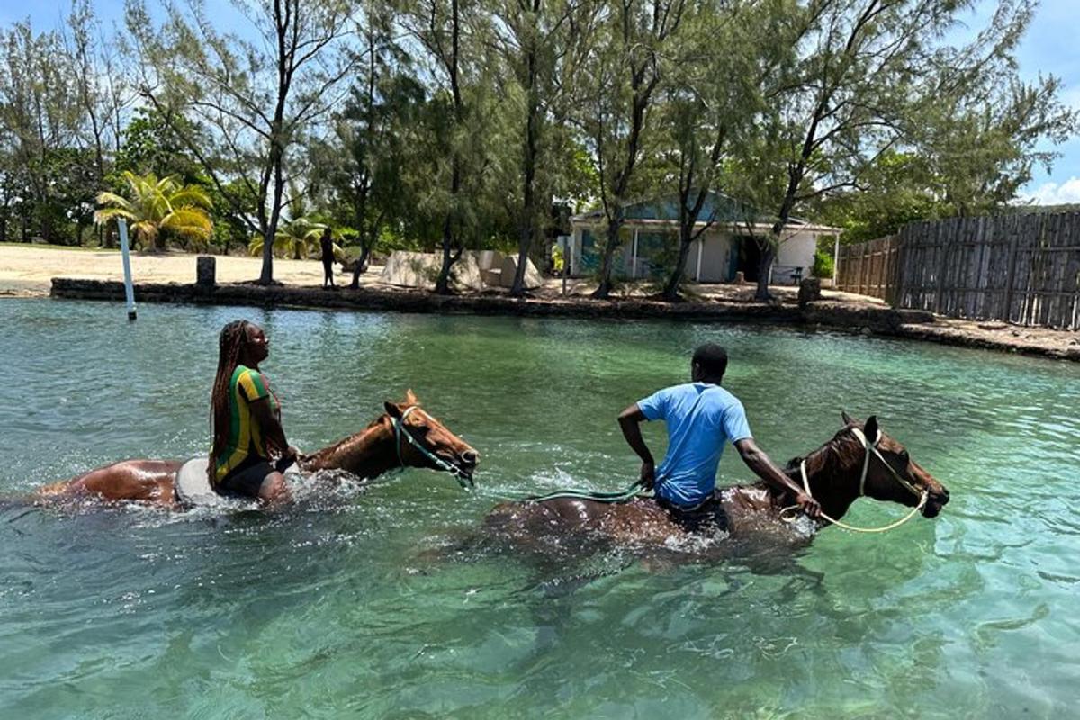 a man and a woman riding horses in the water