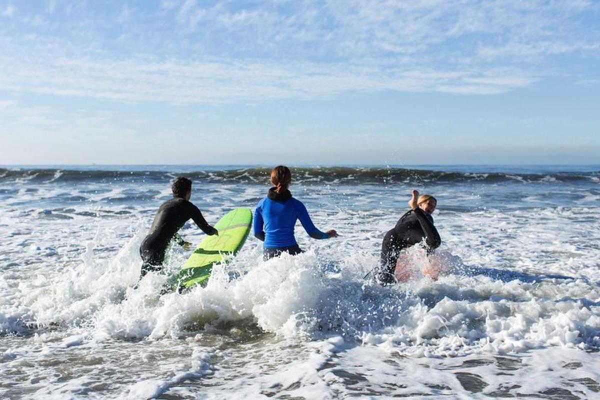 three people in the ocean with surfboards in the water