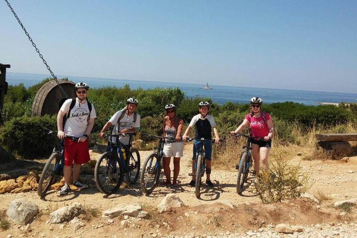 a group of people standing with bikes on a trail