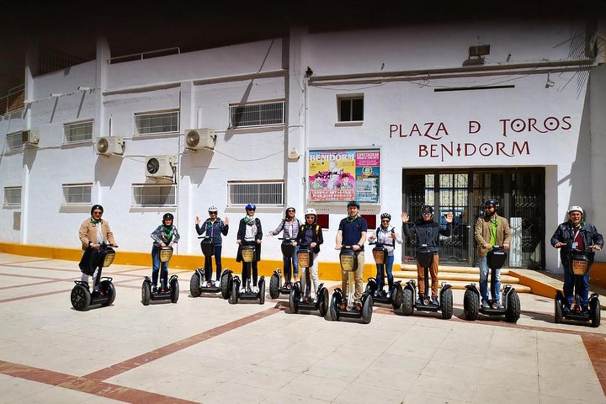 eine Gruppe von Menschen, die auf Segways vor einem Gebäude fahren