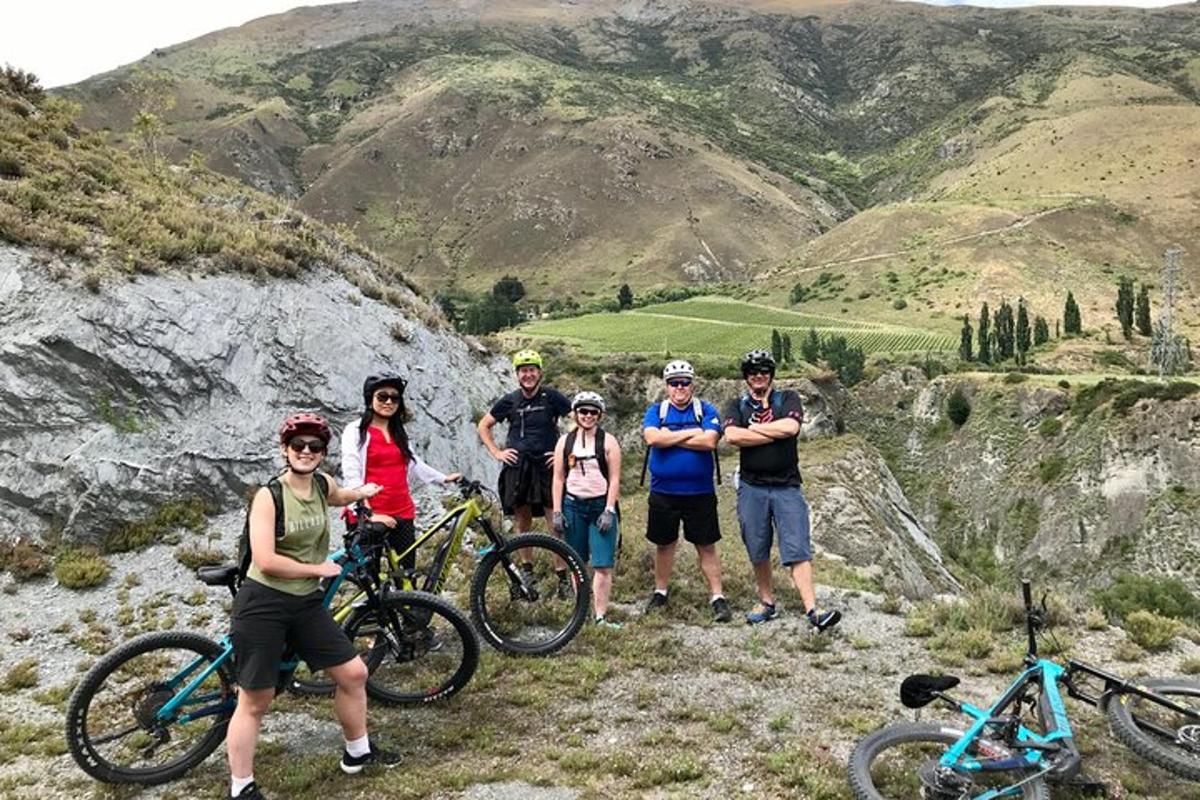 un grup de persones dretes a una muntanya amb bicicletes