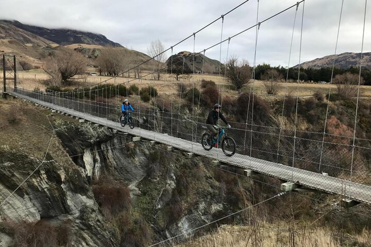 dues persones anant en bicicleta per un pont