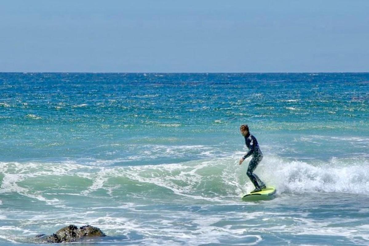 muž jedoucí na vlně na surfovém prkně v oceánu