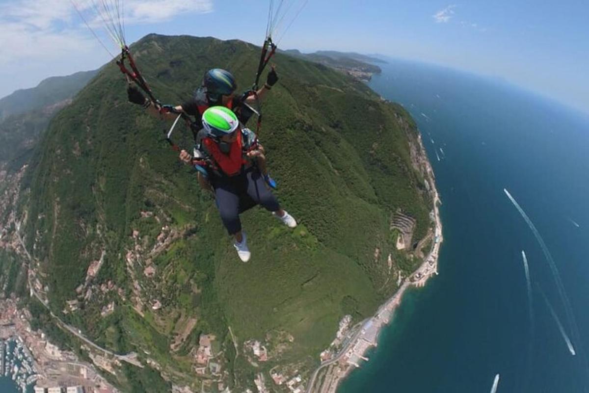due persone appese a un paracadute sopra l'oceano