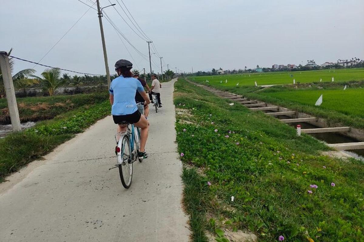 two people riding bikes down a dirt road