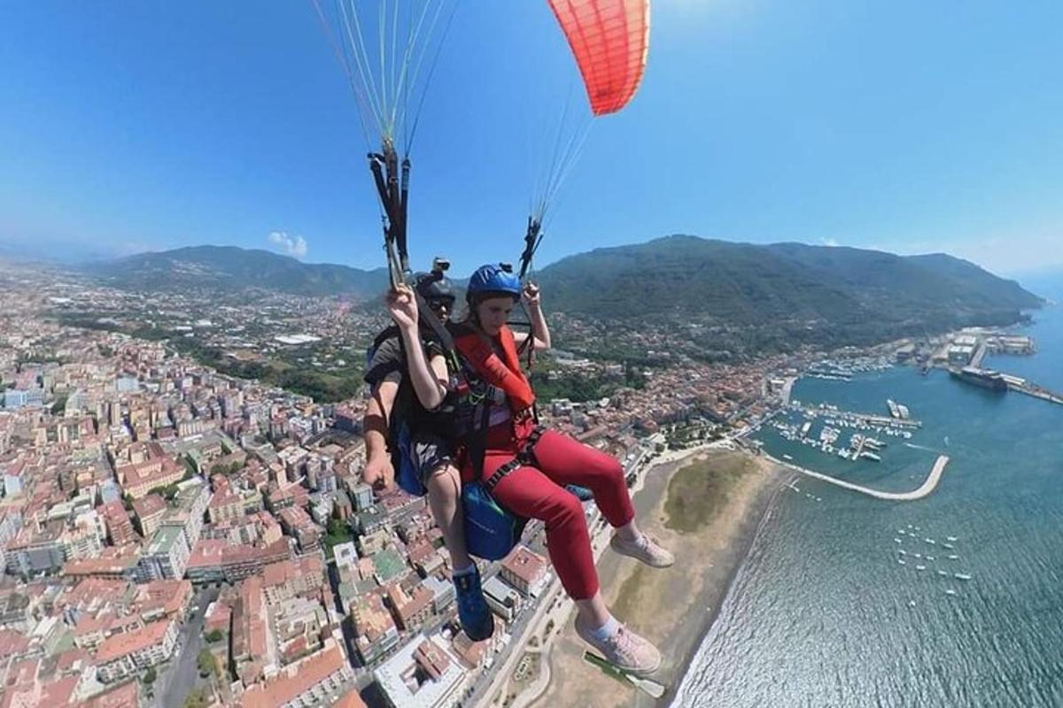 due persone che volano con il paracadute sopra una città